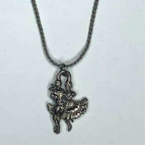 The Silver Dancers Necklace by Square Up Fashions features two dancers in traditional attire on a silver pendant, elegantly hung from an 18-inch chain.