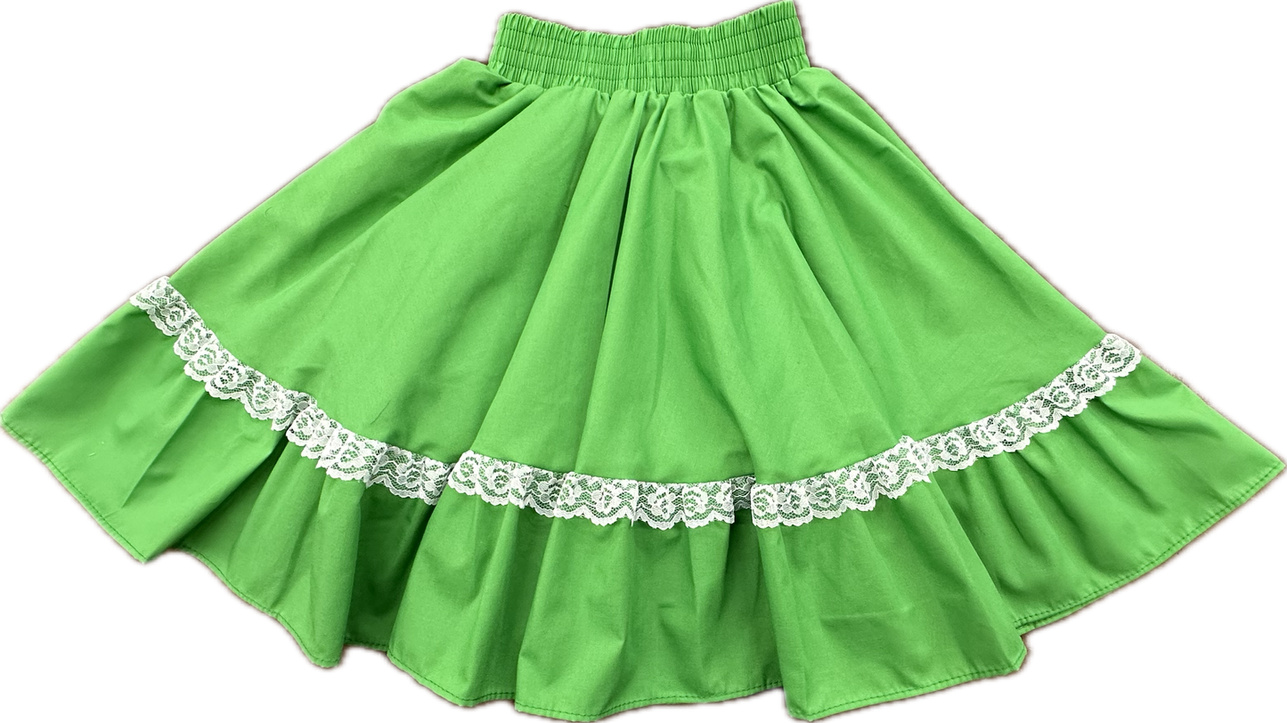Square Up Fashions’ Childrens Circle Skirt features a green fabric, elastic custom waist, and white lace trim near the hem, shown laid flat on a white background.