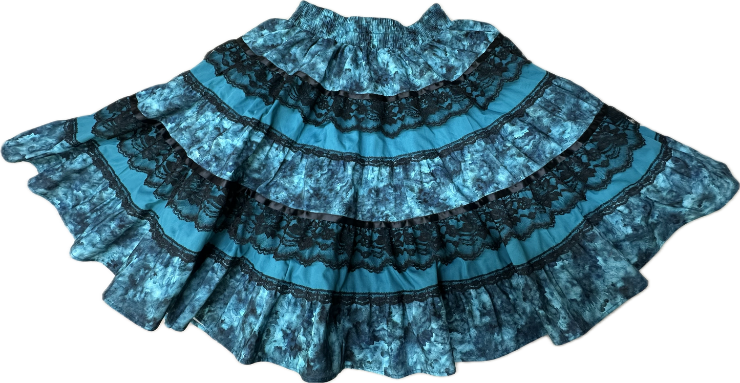 The Tone on Tone Square Dance Skirt by Square Up Fashions is a blue five-tiered skirt with black lace trim and a ruffled hem, shown laid flat against a white background—ideal for enhancing any woman's wardrobe.