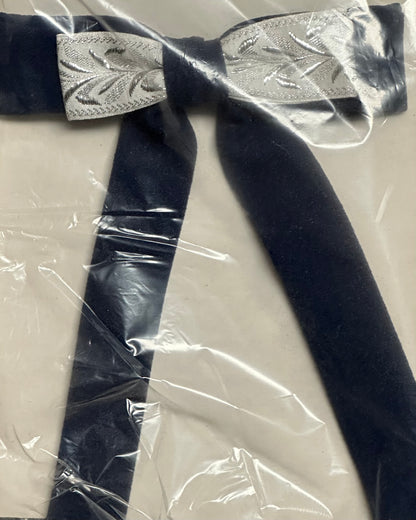 The Colonel Ties by Square Up Fashions encapsulate southern elegance with their sleek black bow tie and silver patterned central ribbon, all beautifully presented in clear plastic packaging for a pristine look.