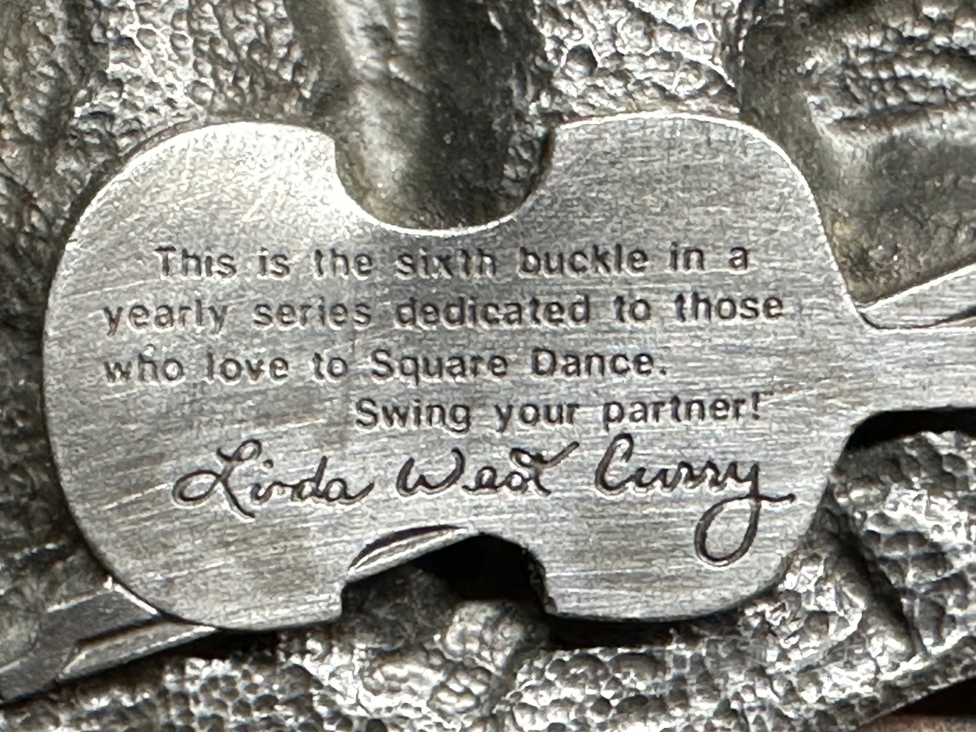 A close-up of the Square Up Fashions "Square Dance Buckle w/caller" shows: "Sixth buckle in a yearly series dedicated to those who love to Square Dance. Swing your partner! Linda Weld Curry." A 1989 commemorative item.