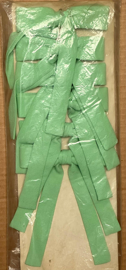 A box containing several neatly stacked Colonel Ties in light green, wrapped in plastic, exudes a subtle Western look from Square Up Fashions.