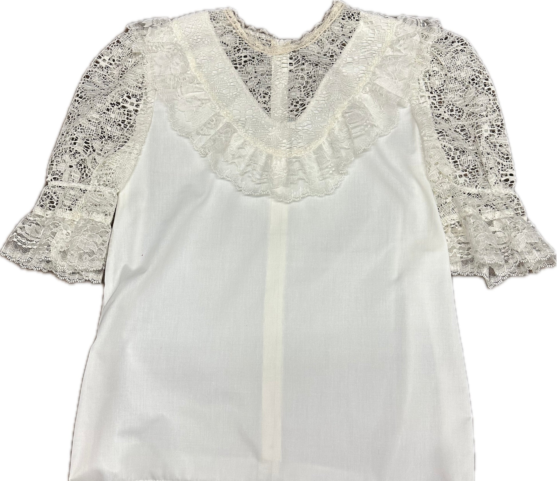 The Elegant Laced Blouse by Square Up Fashions is crafted from soft poly-cotton and features a V-neckline, short flared lace sleeves, and a hem with intricate lace detailing for a stylish touch.