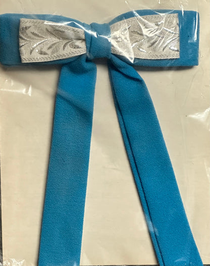 The "Colonel Ties" from Square Up Fashions is a decorative southern bow tie with long tails, showcasing blue fabric with a center strip of silver patterned material, all displayed on a white background.