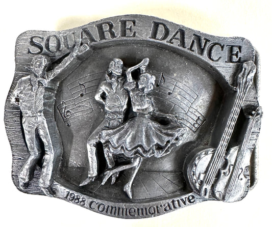Square Up Fashions' "Square Dance Buckle w/ instruments"—a vintage metal plaque with dancers, musical notes, and double bass, commemorating the 1988 National Square Dance in Anaheim. Perfect for square dance collectors!.