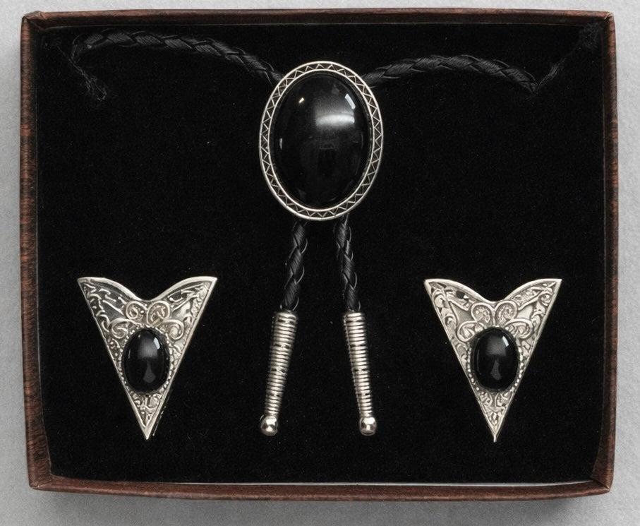 The Western Express Black Stone Bolo Tie & Collar Tip Set features silver plating and black oval stones with engraved designs, presented in a velvet-lined box. Made in the USA.