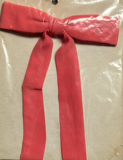 A red Colonel Tie from Square Up Fashions captures the classic southern bow tie charm against a flat, beige background.