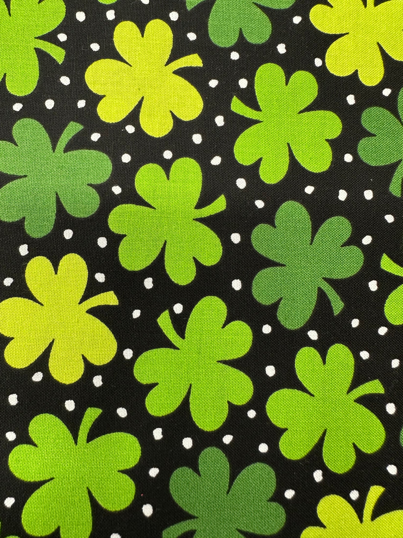 The Lucky Charm Square Dance Skirt by Square Up Fashions features green and yellow four-leaf clovers with white polka dots on black—ideal for a festive St. Patrick's Day look.