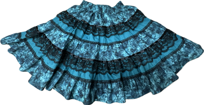 The Tone on Tone Square Dance Skirt by Square Up Fashions is a blue five-tiered skirt with black lace trim and a ruffled hem, shown laid flat against a white background—ideal for enhancing any woman's wardrobe.