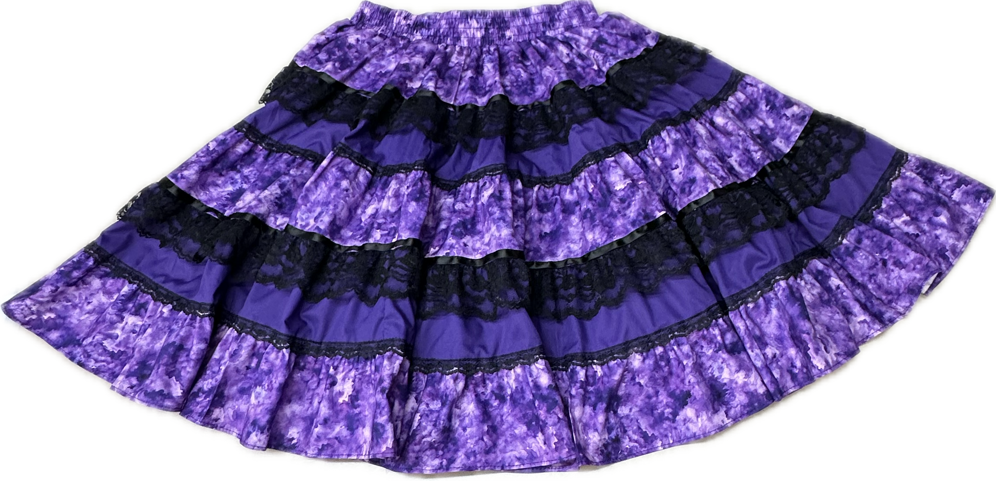 The Square Up Fashions Tone on Tone Square Dance Skirt is a five-tiered purple skirt with black lace trim and an elastic waistband, shown flat on a white background—an ideal piece for any women’s wardrobe.